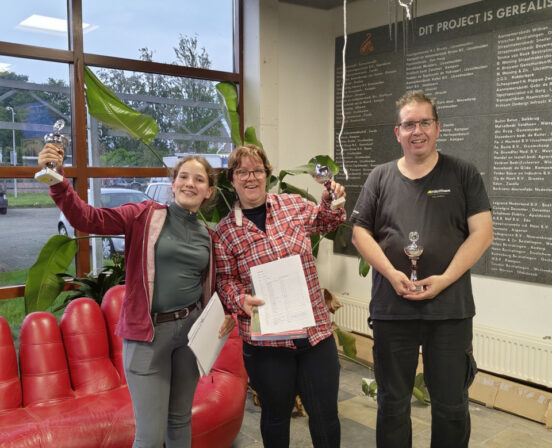 Vrijwilligers Willeke, Sanne en Geert met hun prijzen in de hal van de manege.